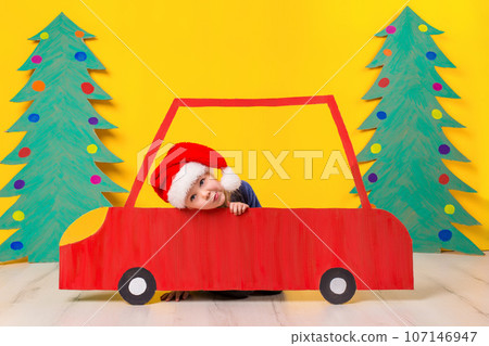 Child in red Christmas car. Xmas holiday concept 107146947