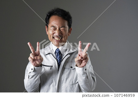 A worker making a peace sign with both hands, black background A worker making a peace sign with both hands, black background 107146959