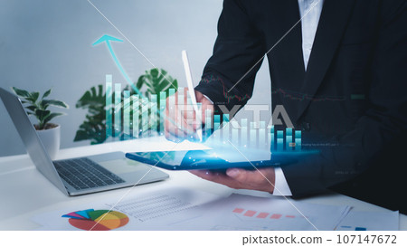 Business development concepts for success and growth. Businessman taps stylus pen on the tablet to display graphs for planning the future growth of the organization, finance, plans, management, 107147672
