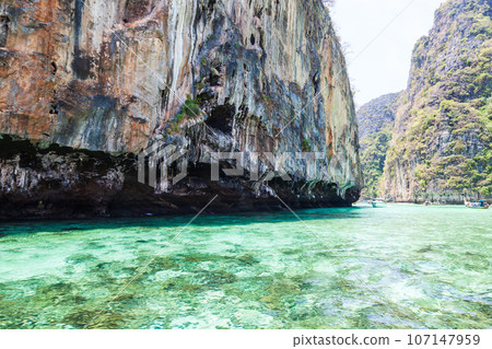 A picturesque beautiful place on the island of Phi Phi Leh - Pi Leh Lagoon is popular for excursions with tourists on traditional Thai fishing boats. Island travel in Thailand. A picturesque beautiful place on the island of Phi Phi Leh - Pi Leh Lagoon is popular for excursions with tourists on traditional Thai fishing boats. Island travel in Thailand. 107147959