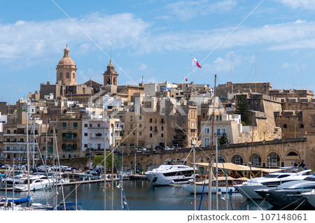 Malta, The view of Birgu with Our Lady of Annunciation church, big dome over the Dockyard bay with moored yacht. Malta, The view of Birgu with Our Lady of Annunciation church, big dome over the Dockyard bay with moored yacht. 107148061
