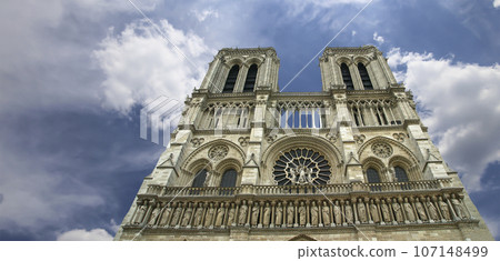 Notre Dame de Paris (against the background of sky with clouds), also known as Notre Dame Cathedral or simply Notre Dame, is a Gothic, Roman Catholic cathedral of Paris, France 107148499