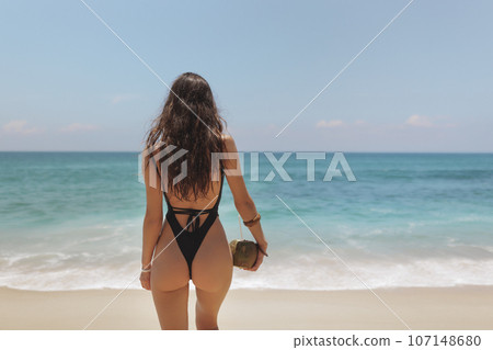 Bikini Beach Woman Buttocks in Black Swimsuit on Perfect Beach  107148680