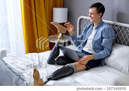 positive disabled man use modern technologies. adult guy with prostheses have fun 107148930