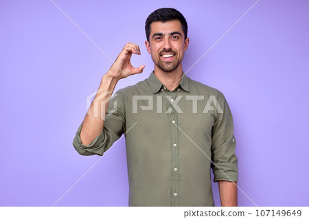 smiling deaf man wearing green shirt using sign language on blue background 107149649