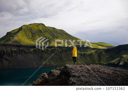 Backpacker girl smiling with the view of Icelandic Highlands Backpacker girl smiling with the view of Icelandic Highlands 107151362