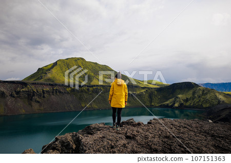 Backpacker girl contemplating the beauty of Blahylur lake in Iceland 107151363