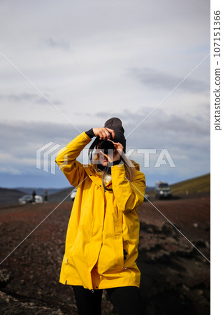 The traveler girl in the yellow trekking jacket making a photo in the Icelandic highlands 107151366