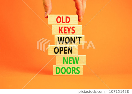 Old keys do not open new doors symbol. Concept words Old keys do not open new doors. Beautiful orange table background. Businessman hand. Business popular quotation old key new door concept Copy space 107151428