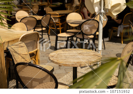 Empty restaurant summer terrace with tables and chairs. Reastaurant tables waiting for customers at an outdoor terrace, hipster style 107151932
