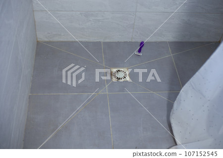 Hair in the shower sink and razor on the floor. Clogged sink after hair. 107152545