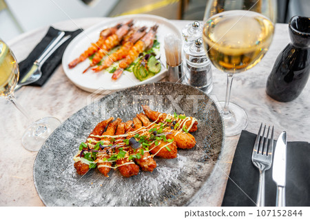 King prawns battered in panko raincoat with a sauce on a gray plate 107152844