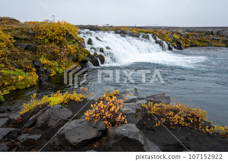 Grafarlandsfoss falls amidst autumn vegetation and black lava fields, Iceland. Grafarlandsfoss falls amidst autumn vegetation and black lava fields, Iceland. 107152922