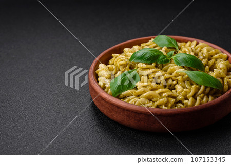 Delicious fresh pasta with green pesto sauce with basil 107153345