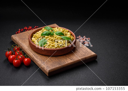 Delicious fresh pasta with green pesto sauce with basil Delicious fresh pasta with green pesto sauce with basil 107153355