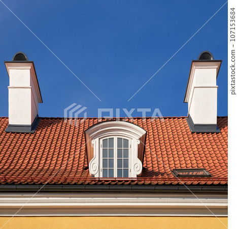 Old vintage garret roof with window and chimneys. Retro attic window and fireplace chimneys, Riga, Latvia. Old vintage garret roof with window and chimneys. Retro attic window and fireplace chimneys, Riga, Latvia. 107153684
