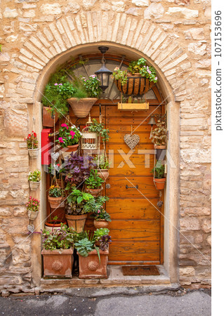 Wooden door decorated with flowers in pots. Wooden door decorated with flowers in pots. 107153696