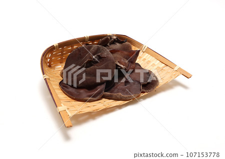 Wood ear mushrooms on a colander on a white background 107153778