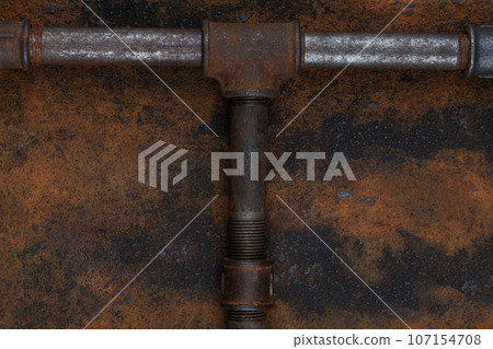 Rusty plumb tube on rusty metal wall 107154708