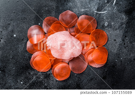 Raw kerupuk or prawn shrimp crackers, chips. Black background. Top view 107155089