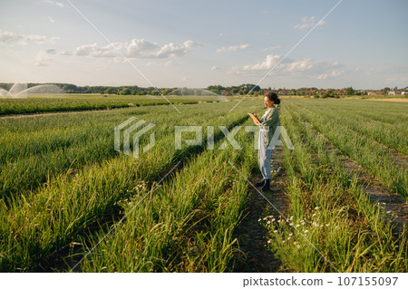 Female agronomist with clipboard standing on field . Agricultural occupation concept 107155097