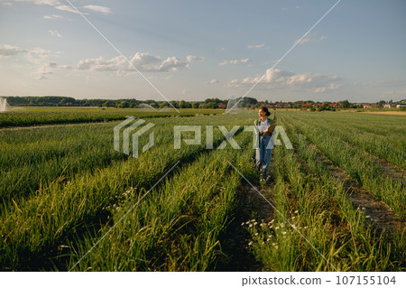 Female agronomist with clipboard standing field during harvesting. Agricultural occupation concept 107155104