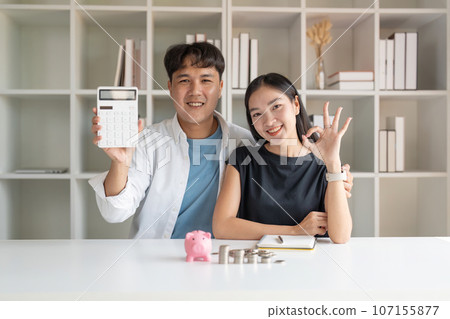 Asian young couple use calculator calculate expenses finance and discuss plan together at home Asian young couple use calculator calculate expenses finance and discuss plan together at home 107155877