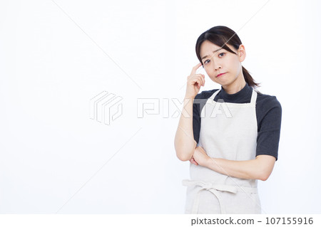 一位 30 多歲的家庭主婦在白色背景前嚴重擔心 一位 30 多歲的家庭主婦在白色背景前嚴重擔心 107155916