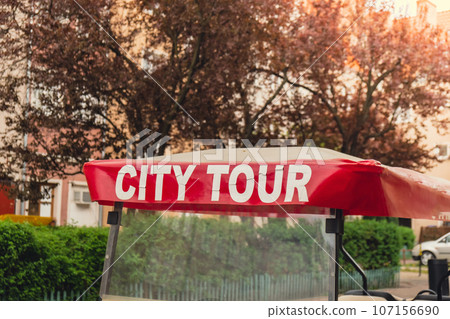 Red City tour car in the old city with text sign of Sightseeing city tour. Guided tour in Gdansk by car. Tourist attraction 107156690