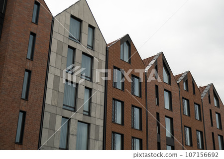 Modern office building exterior with glass facade on clear sky background. Transparent glass wall of office building with yellow decoration. Element of facade of modern European building Commercial Modern office building exterior with glass facade on clear sky background. Transparent glass wall of office building with yellow decoration. Element of facade of modern European building Commercial 107156692
