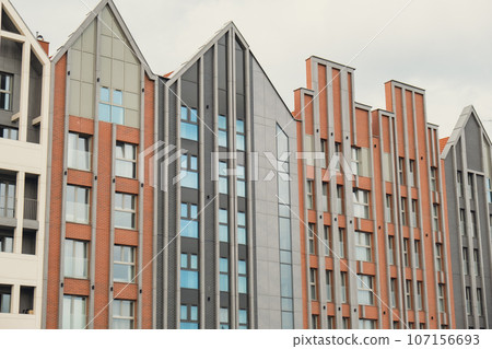 Modern office building exterior with glass facade on clear sky background. Transparent glass wall of office building with yellow decoration. Element of facade of modern European building Commercial Modern office building exterior with glass facade on clear sky background. Transparent glass wall of office building with yellow decoration. Element of facade of modern European building Commercial 107156693