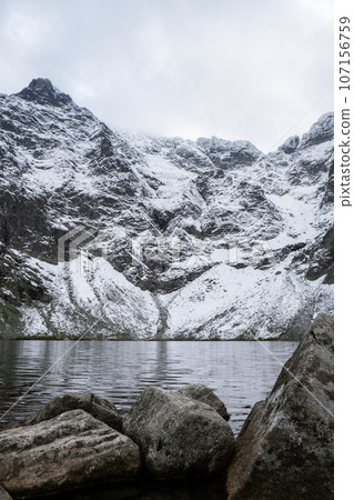 Czarny Staw pod Rysamy or Black Pond lake near the Morskie Oko Snowy Mountain Hut in Polish Tatry mountains, drone view, Zakopane, Poland. 4k Aerial view shot of beautiful green hills and mountains in 107156759