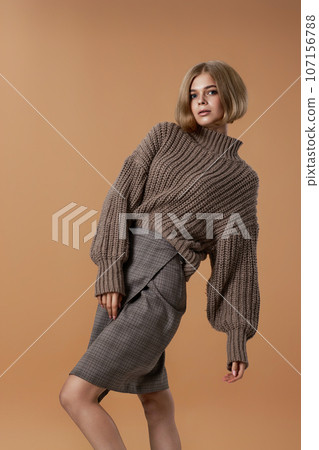 beautiful blonde woman in brown knitted sweater beautiful blonde woman in brown knitted sweater 107156788