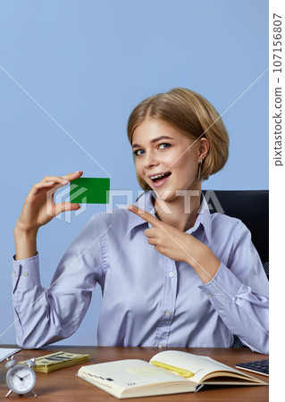 beautiful blonde businesswoman holding plastic credit card 107156807