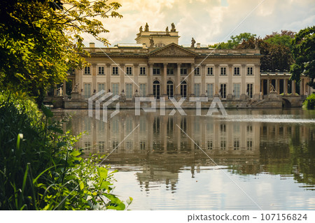 Baths classicist Palace on the Isle in Lazienki Park touristic place in Warsaw. Lazienki Royal Baths Park, Baroque columns Warsaw Poland. Mirror Reflection on the Lake Baths classicist Palace on the Isle in Lazienki Park touristic place in Warsaw. Lazienki Royal Baths Park, Baroque columns Warsaw Poland. Mirror Reflection on the Lake 107156824