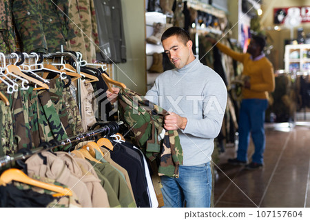 Man choosing camouflage clothes 107157604