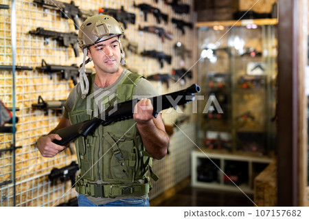 Man in army uniform with weapon in military market 107157682