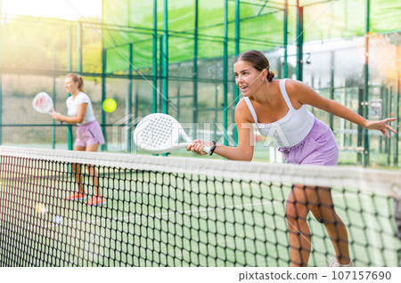 Two women tennis players playing padel 107157690