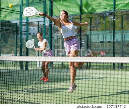Two women tennis players playing padel 107157742