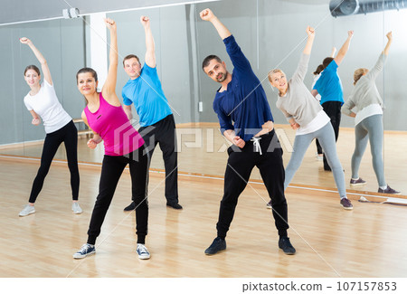 Women and men warming up during dance class Women and men warming up during dance class 107157853