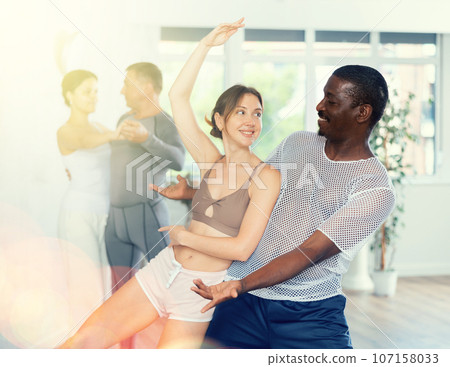 Smiling African American man supporting young woman in dance Smiling African American man supporting young woman in dance 107158033
