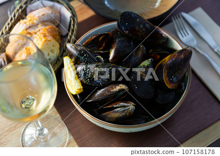 Steamed tasty mussels with green sauce at plate, nobody 107158178