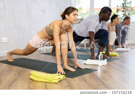 Young sporty woman doing Ashwa Sanchalanasana lunging yoga pose Young sporty woman doing Ashwa Sanchalanasana lunging yoga pose 107158238