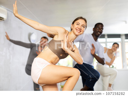 Young woman dancing in group in studio 107158282
