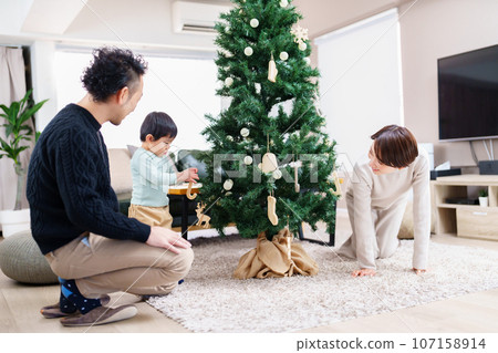 Family decorating the Christmas tree 107158914