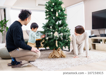Family decorating the Christmas tree 107158915