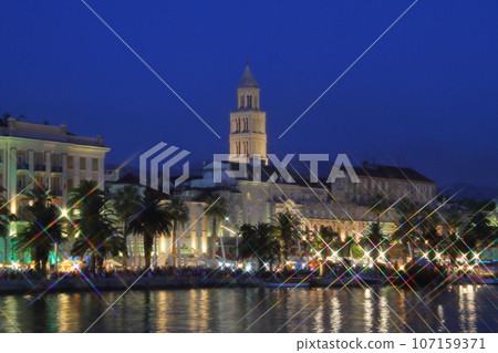 Split, a world cultural heritage site in Croatia, a port city on the Adriatic Sea, night view of Diocletian's Palace and cityscape across the sea Split, a world cultural heritage site in Croatia, a port city on the Adriatic Sea, night view of Diocletian's Palace and cityscape across the sea 107159371