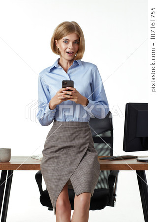 blonde business woman using phone in the office blonde business woman using phone in the office 107161755