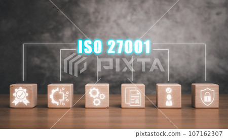 Iso 27001 concept, Wooden block on desk with iso 27001 icon on virtual screen. 107162307