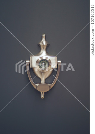 Classic brass door knocker on a wood background Classic brass door knocker on a wood background 107163513